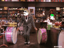 a man in a suit is playing drums in a store with a sign that says $ doood