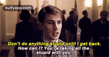 a man in a suit and tie is talking to another man in a crowd of people .