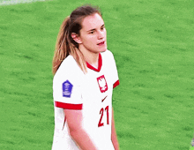 a female soccer player wearing number 21 smiles
