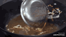 a strainer is being poured into a pot of soup with the words made in animatica below it