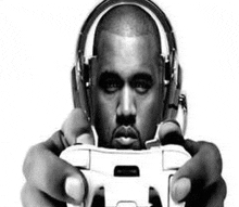 kanye west wearing headphones is holding a video game controller .