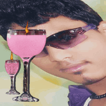 a man wearing sunglasses looks at a pink wine glass