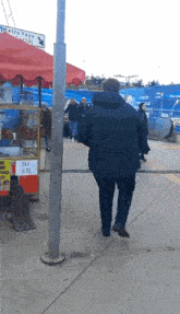 a man is walking past a sign that says su 5tl