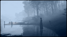 a man stands on a dock in the fog
