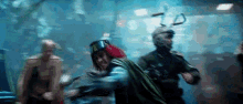 a group of people are standing in a dark room . one of the people is wearing a green cape .