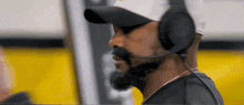 a man wearing a hat and headphones with jbl written on them