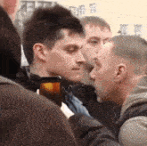 a man is taking a picture of another man with his phone .