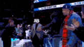 a group of people are standing in front of an all star celebrity game banner