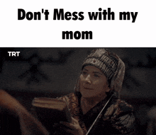 a woman is holding a piece of paper and says " don 't mess with my mom " .