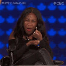 a woman in a wheelchair is laughing while wearing a tag that says ta on it