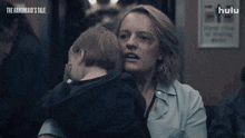 a woman holding a child with the words the handmaid 's tale on the bottom