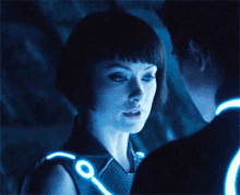 a man and a woman are looking at each other in a blue light