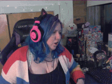 a woman with blue hair is wearing headphones and sitting in a dxr gaming chair