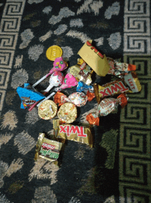 a bunch of candy including a twix bar on a rug