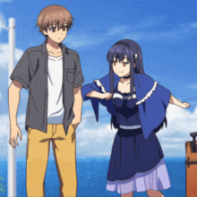 a man and a girl are standing next to each other in front of the ocean