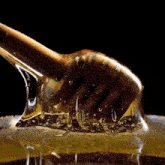 a honey dipper is being used to pour honey into a glass