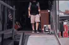 a man is walking out of a trailer with a ramp and stairs .