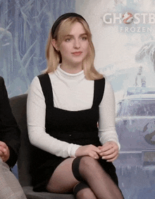 a woman is sitting in front of a ghostbusters poster