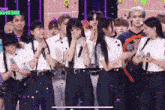 a group of people are standing on a stage with microphones and confetti