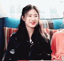 two girls are sitting on a couch and one has the word fow on the bottom right