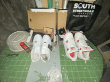 a south streetwear garage bag sits next to a pair of white sneakers