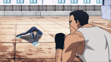 a man in a white tank top looks at a man doing a handstand