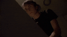 a young man in a black shirt is looking up at something