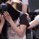 a woman covering her face with her hair wearing a shirt that says club 19 on it