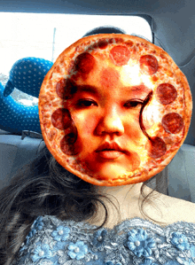 a girl in a blue dress has a pizza face on her face