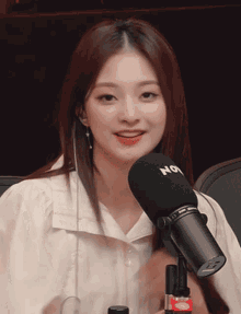 a woman is sitting in front of a microphone that says nox