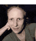 a woman in a green shirt looks at the camera