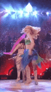a woman in a green top is dancing on stage