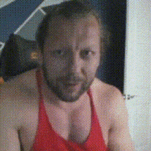 a man with a beard wearing a red tank top