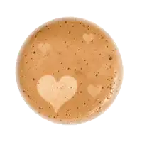 a close up of a cup of coffee with a heart shaped foam