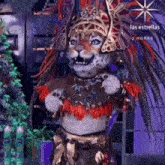 a leopard is wearing a costume with feathers and a crown .