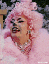 a close up of a drag queen with a pink fur coat