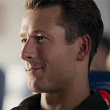 a close up of a man 's face with his eyes closed and a smile on his face