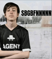 a man wearing a shirt that says agent with his arms crossed