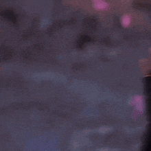 a blurred image of a person 's face with a purple background