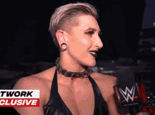 a woman is talking into a microphone with a wwe logo on it