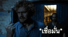 a man in a blue shirt is standing in front of a door with a foreign language written on it