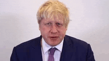 a close up of a man in a suit and tie making a face .