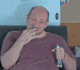 a man brushing his teeth with a tube of toothpaste