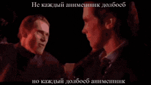 two men are standing next to each other in a dark room with russian writing on the bottom right