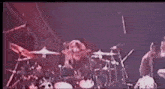 a drum set is being played on a stage in a dark room .