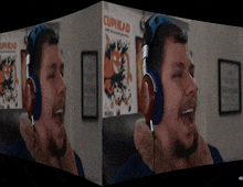 a man wearing headphones is screaming in front of a cuphead poster