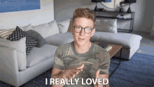 a man in a camo shirt says i really loved in front of a couch