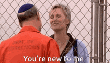 a man in a dept of corrections uniform is talking to a woman