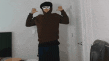a man wearing a hoodie and glasses is standing in a hallway