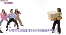 a group of women holding a cardboard box with the show written on the bottom right